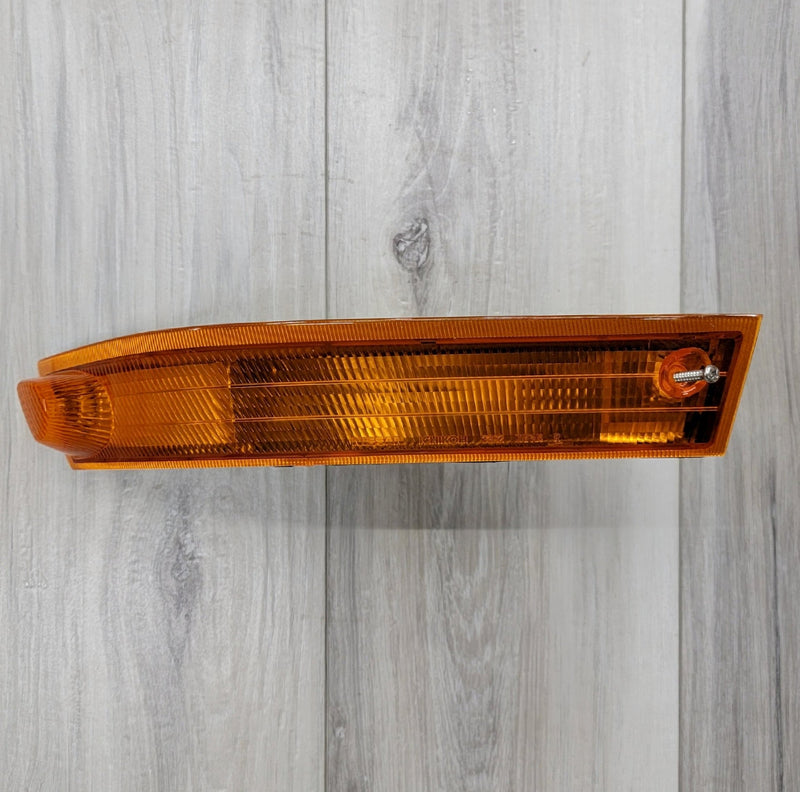 Load image into Gallery viewer, Amber JDM left-hand turn signal lamp assembly for Nissan S14 Kouki on a wood-grain background.