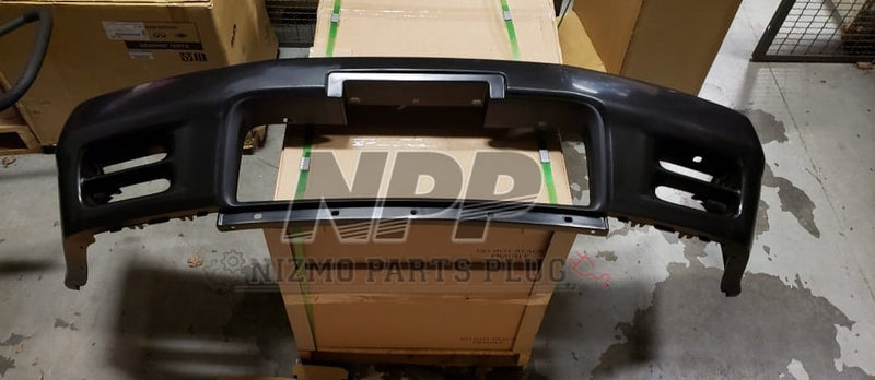 Load image into Gallery viewer, Black Nissan R32 Skyline GTR front bumper assembly in excellent condition on a cardboard shipping box.