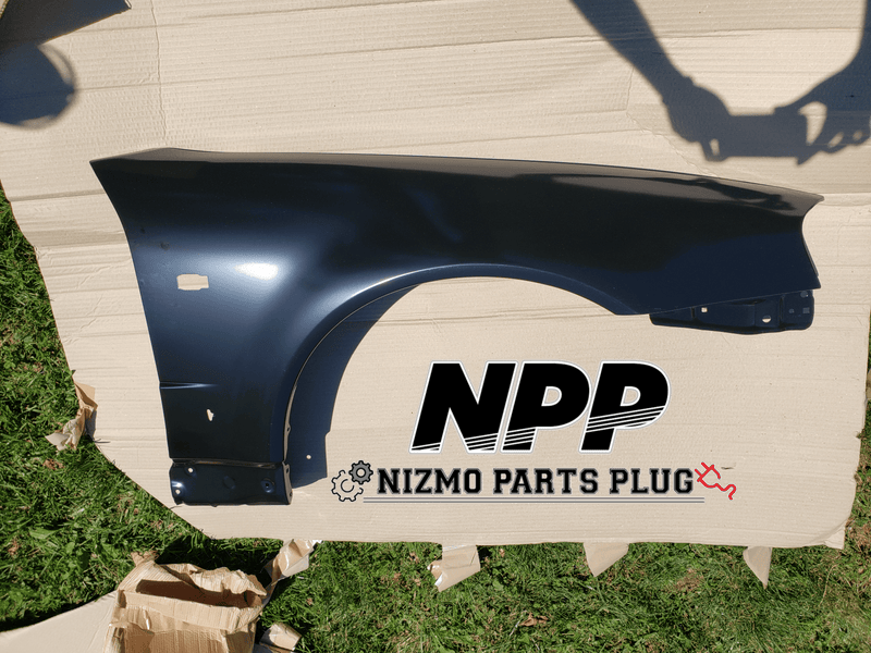 ギャラリービューアに画像をロードする, Dark blue RH front fender for R34 Skyline GTR in excellent condition, displayed on cardboard.