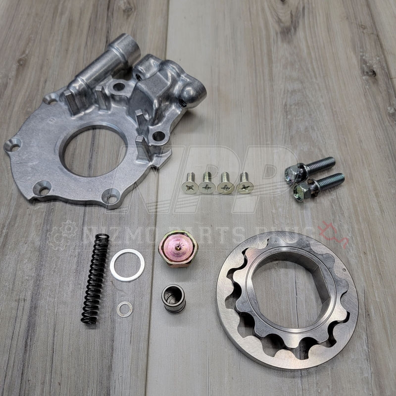 Load image into Gallery viewer, New silver Nissan S13 240SX KA24DE engine oil pump kit including housing, gears, spring, and hardware on wood floor.