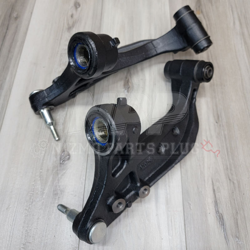 Load image into Gallery viewer, Pair of black R33/34 GTR front extension knuckle arms in excellent condition on a wood background.