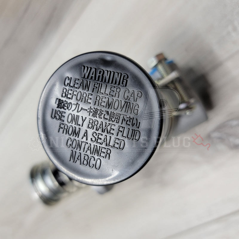 Load image into Gallery viewer, New Nissan R32/R33/R34 GTR clutch master cylinder, focusing on the black filler cap with embossed English/Japanese text.