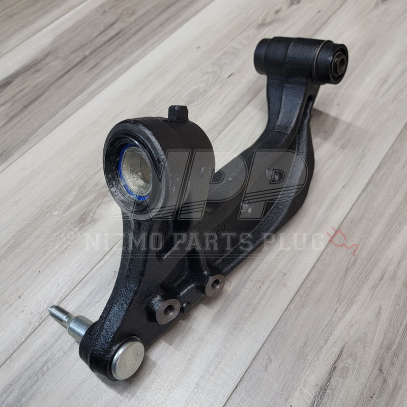 Load image into Gallery viewer, Black Nissan R33/R34 Skyline front knuckle extension arm with integrated bushing and ball joint on wood floor.