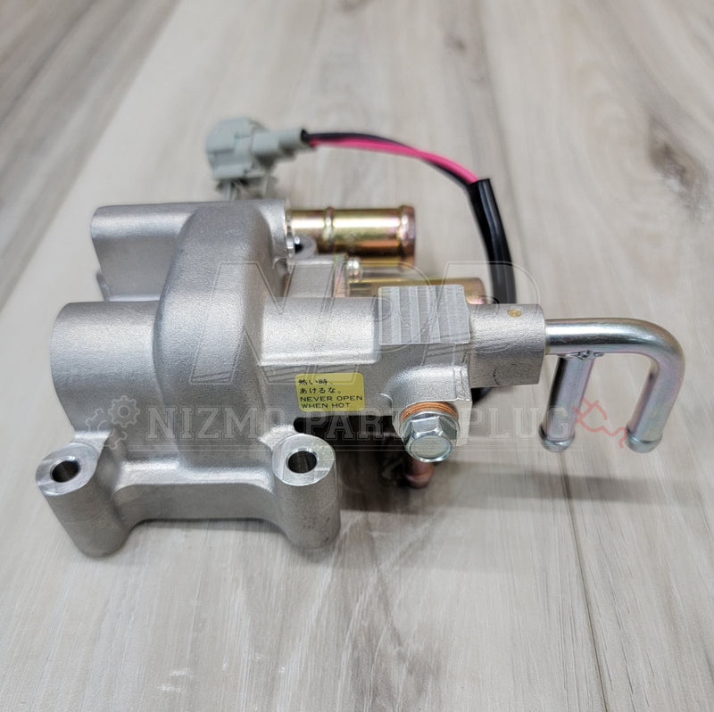 Load image into Gallery viewer, Nissan R34 Skyline RB25DET NEO idle air control valve in silver with warning sticker and electrical connector.