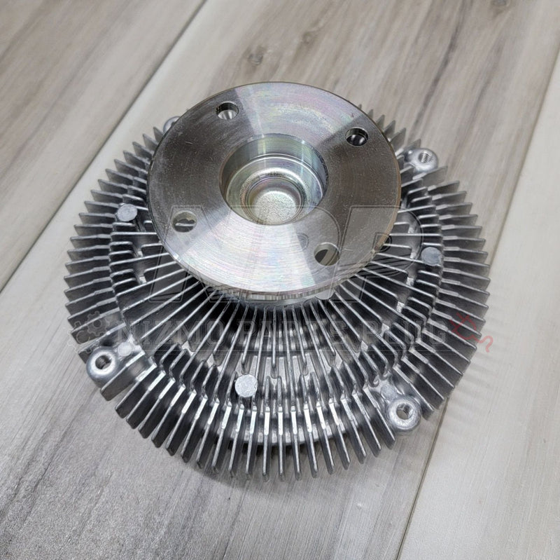 Load image into Gallery viewer, New silver aluminum clutch fan coupler for Nissan R33 and R34 Skyline GTR on wood background.