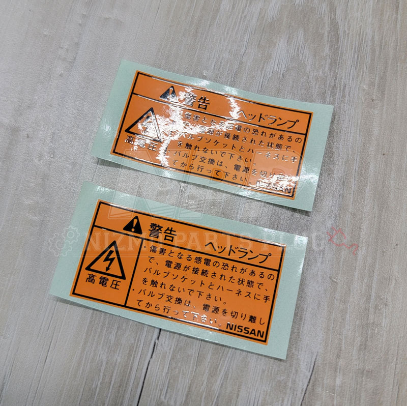 Load image into Gallery viewer, Nissan R34 Skyline Headlight H.I.D. Warning Label Set - NizmoPartsPlug