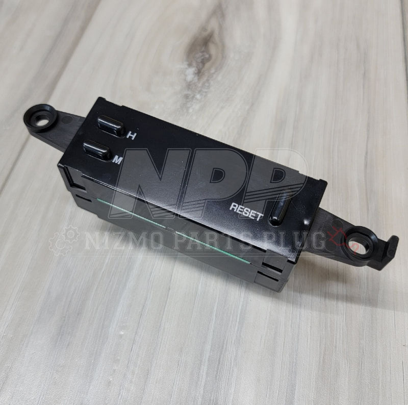 Load image into Gallery viewer, Black Nissan R32 Skyline GTR digital cluster clock assembly with H, M, and RESET buttons on a wood grain background.