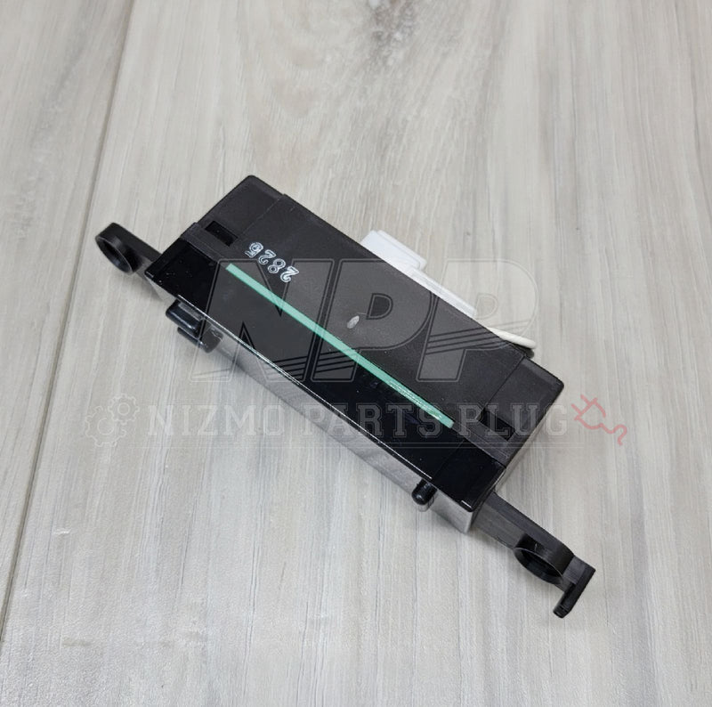 Load image into Gallery viewer, Black Nissan R32 Skyline GTR cluster clock assembly with white connector and white markings on a wood grain surface.