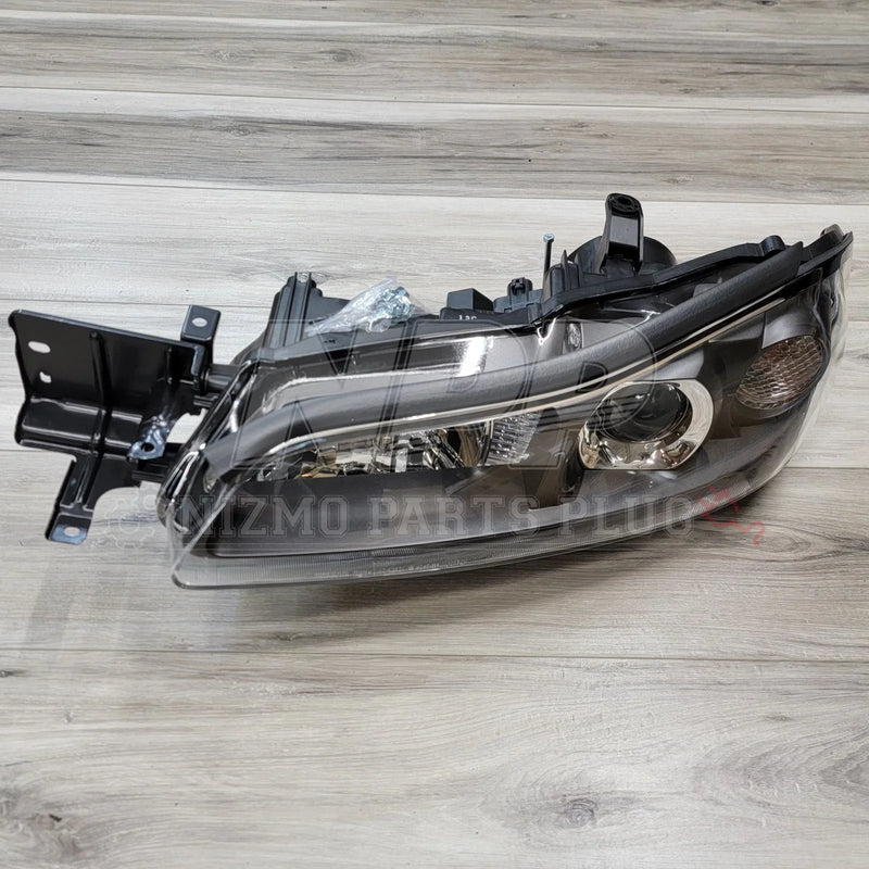 Load image into Gallery viewer, Nissan S15 Silvia HID LH Projector Headlight Assembly displayed on a wooden surface showcasing its sleek design and components.