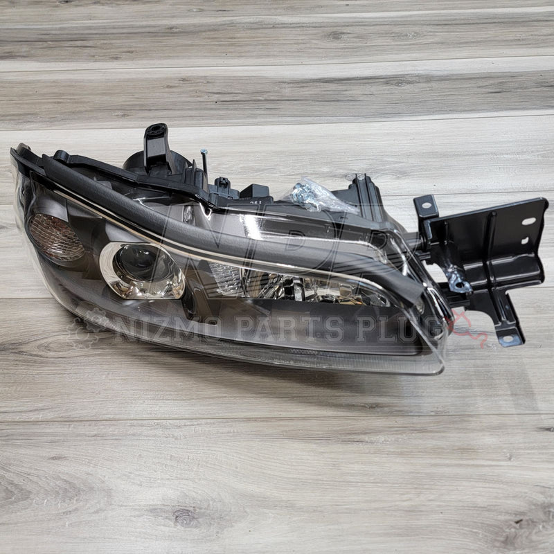 Load image into Gallery viewer, OEM Nissan S15 Silvia HID headlight assembly with black housing on a wood background.