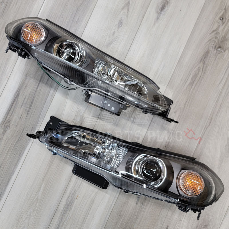 Load image into Gallery viewer, OEM Nissan S15 Silvia HID headlight assembly set with clean clear lenses and black housings on a wood floor.