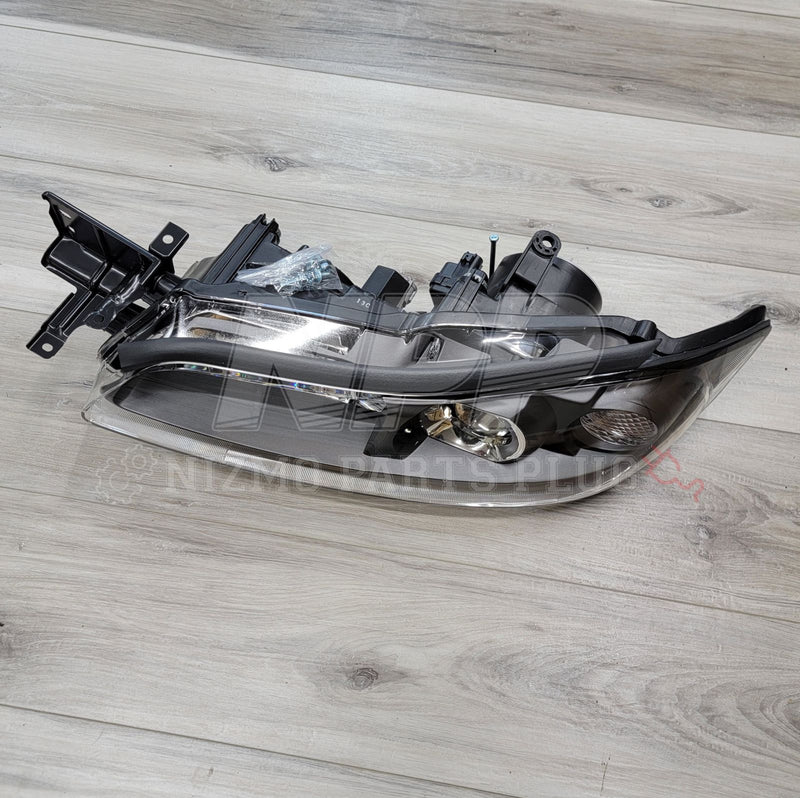 Load image into Gallery viewer, OEM Nissan S15 Silvia HID headlight assembly, black housing, clean condition, on a light wood background.