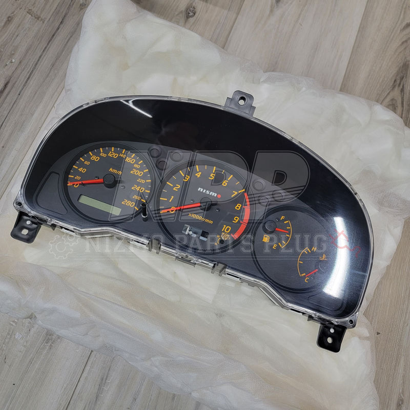Load image into Gallery viewer, Nismo combination meter for Nissan Silvia S15 with black gauge faces, orange needles, and 10k RPM tachometer.