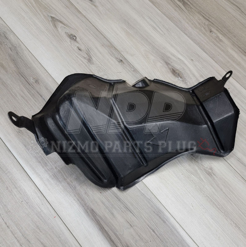 Load image into Gallery viewer, Black plastic fuel filler neck protector cover for Nissan R34 Skyline, shown from above on a wood background.