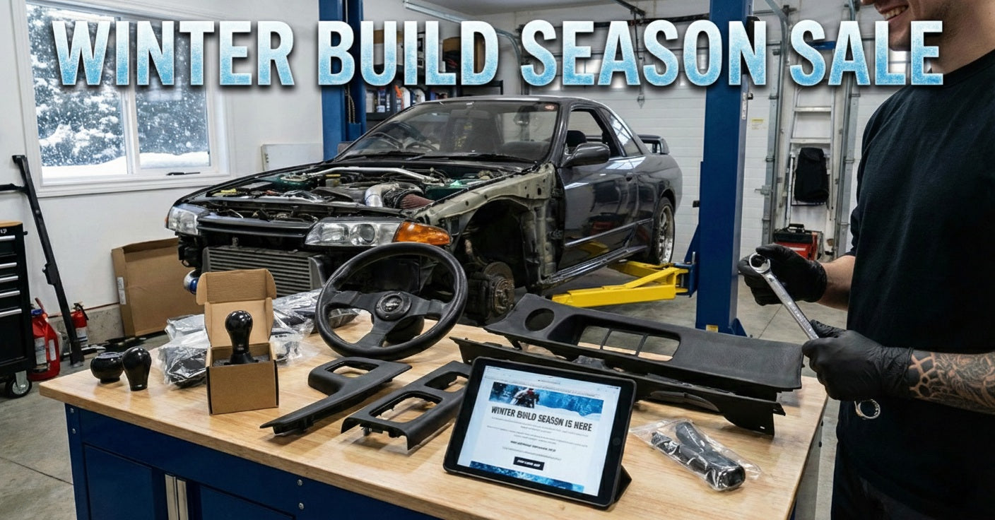 Automotive parts on a workbench with a car in the background and text about a winter build season sale.