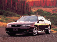 Black sports car on a scenic road with red rock formations in the background