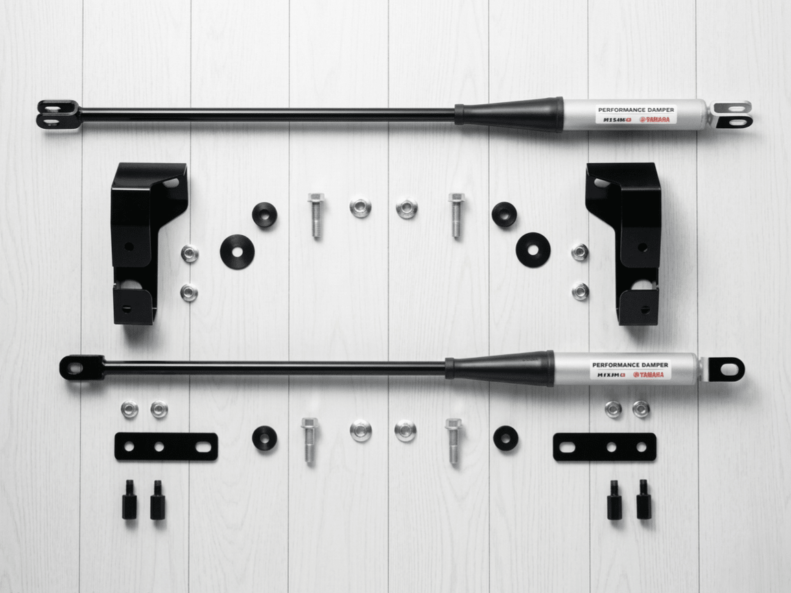 New Nissan R34 Skyline GTR Nismo Yamaha performance damper set with silver struts, black brackets, and hardware.