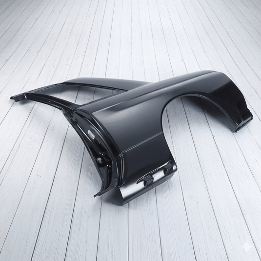 New Nissan R32 GTR LH quarter panel assembly in black primer on a white wooden floor.