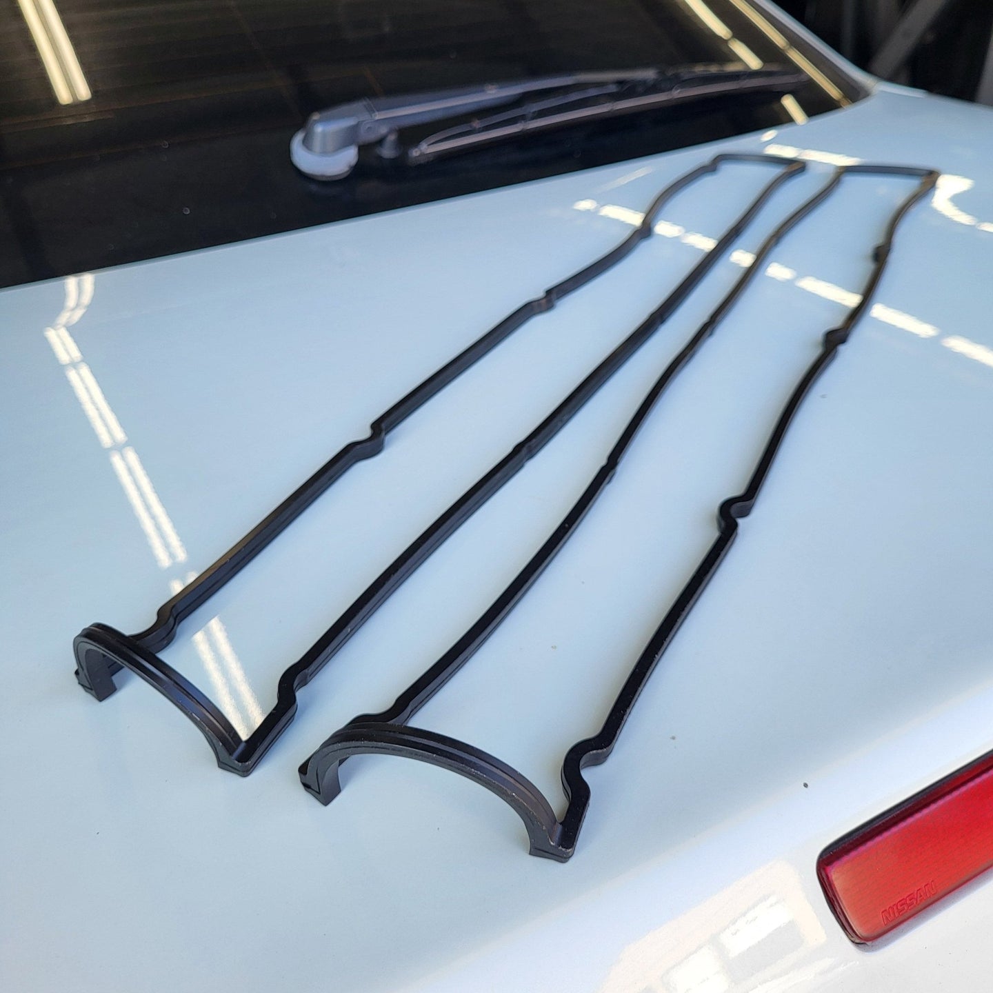 Cometic Gaskets RB26 RB25 RB20 valve cover gasket set displayed on a vehicle surface.