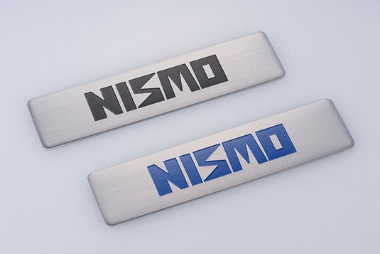 40th Anniversary NISMO metal emblem set with black and blue logo variants on brushed silver plates.