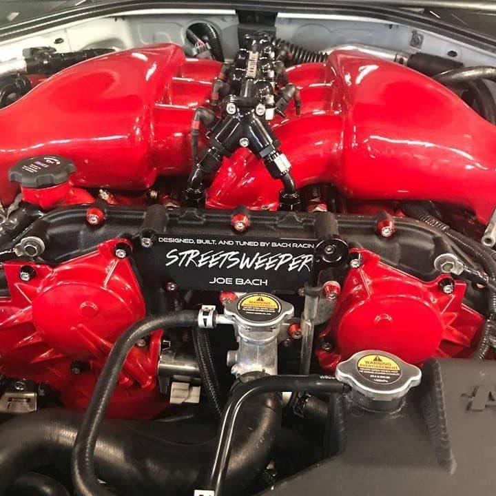 Cargue la imagen en el visor de la galería, ZSPEC fastener kit installed on a Nissan GTR R35 engine bay featuring red engine covers and red billet bolt hardware.

