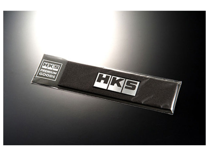 Load image into Gallery viewer, New silver HKS emblem for universal automotive use, packaged in original HKS Premium Goods retail wrap.
