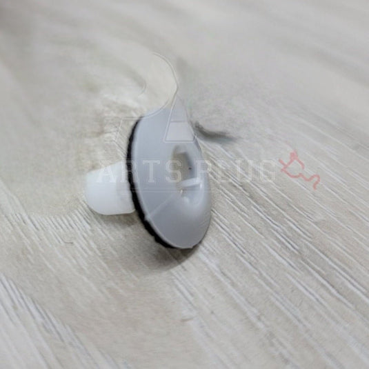White suction cup on a textured beige surface