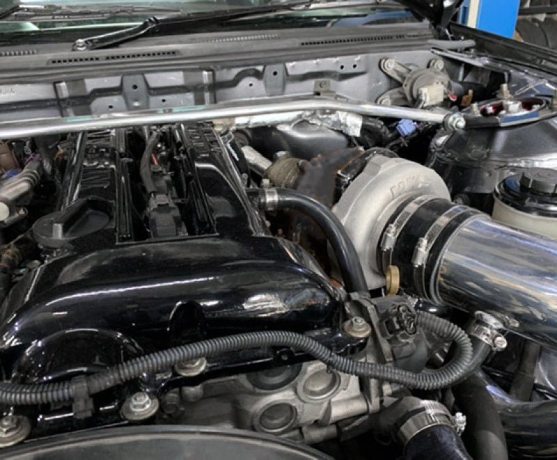 Load image into Gallery viewer, HKS full turbine kit installed on a Nissan S14/S15 SR20DET engine with a polished intake pipe and black valve cover.
