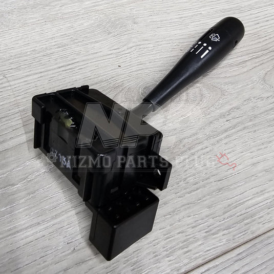 Black Nissan S13 240SX USDM wiper switch assembly with white indicator icons on a light wood grain surface.