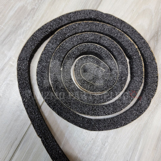 Coiled black foam rubber windshield dam sealer for Nissan S15 Silvia on a light wood surface.