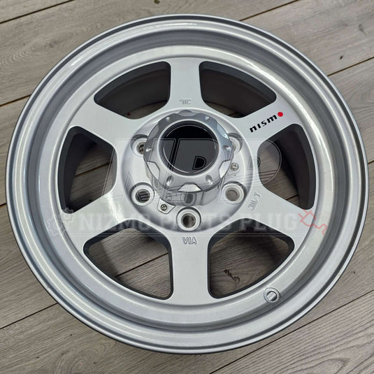 Nismo Frontier Rays Engineering TE37X Wheel Assembly 16x7 6 lug on wooden background.