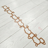 Nissan Skyline GTR RB26DETT Intake Manifold To Cylinder Head Gasket on a wooden floor.