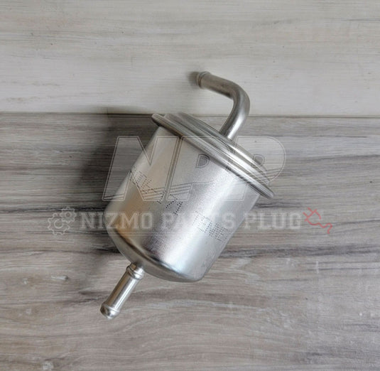 Metal fuel filter on a wooden surface with Nizmo Filters Plug logo.