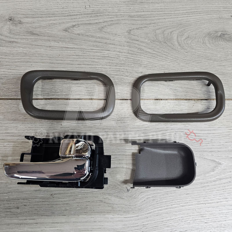 Load image into Gallery viewer, Chrome interior door handle set for Nissan S15 Silvia with grey plastic trim pieces on a wooden background.
