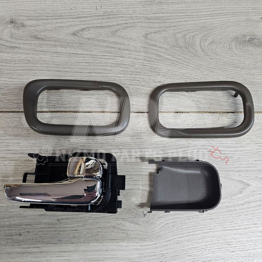 Chrome interior door handle set for Nissan S15 Silvia with grey plastic trim pieces on a wooden background.
