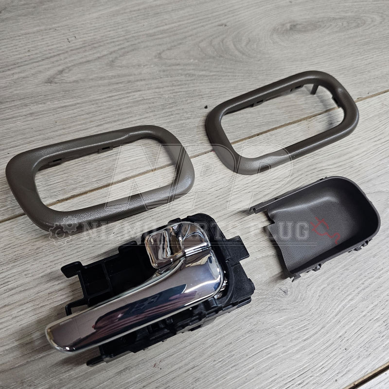 Load image into Gallery viewer, Nissan S15 Silvia chrome interior door handle set with grey trim bezels and plastic housing on a wooden surface.
