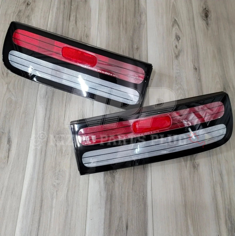 ギャラリービューアに画像をロードする, Pair of rectangular red and clear car tail lights on wooden floor
