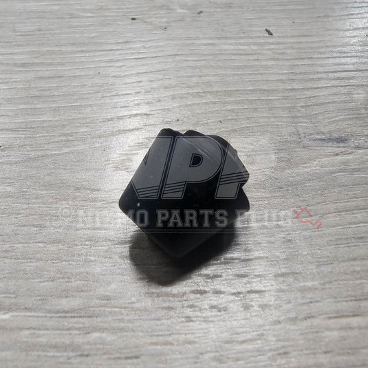 Black rubber door bumper stopper for Nissan R32 Skyline, shown on a wooden surface.