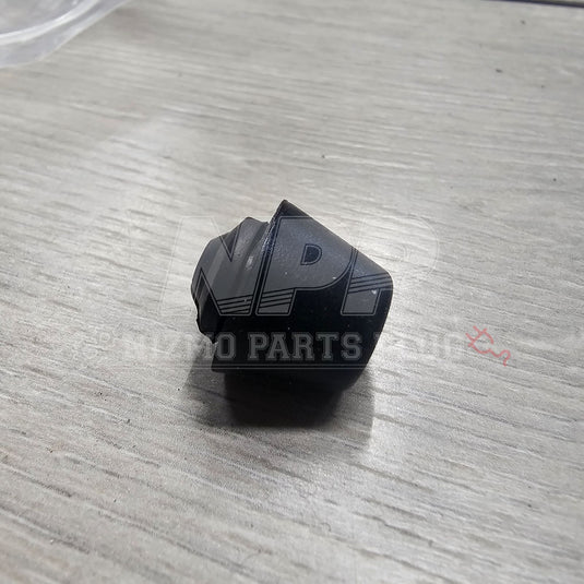 Black rubber door bumper stopper for Nissan R32 Skyline, new condition, conical shape on a light wooden surface.