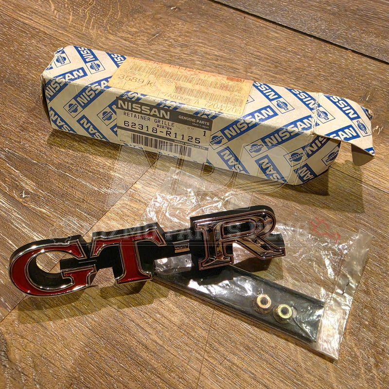 Cargue la imagen en el visor de la galería, Nissan Skyline GT-R Front Grille Emblem Assembly - Rare NOS Part (62318-R1125) KPGC10 / PGC10 - NizmoPartsPlug

