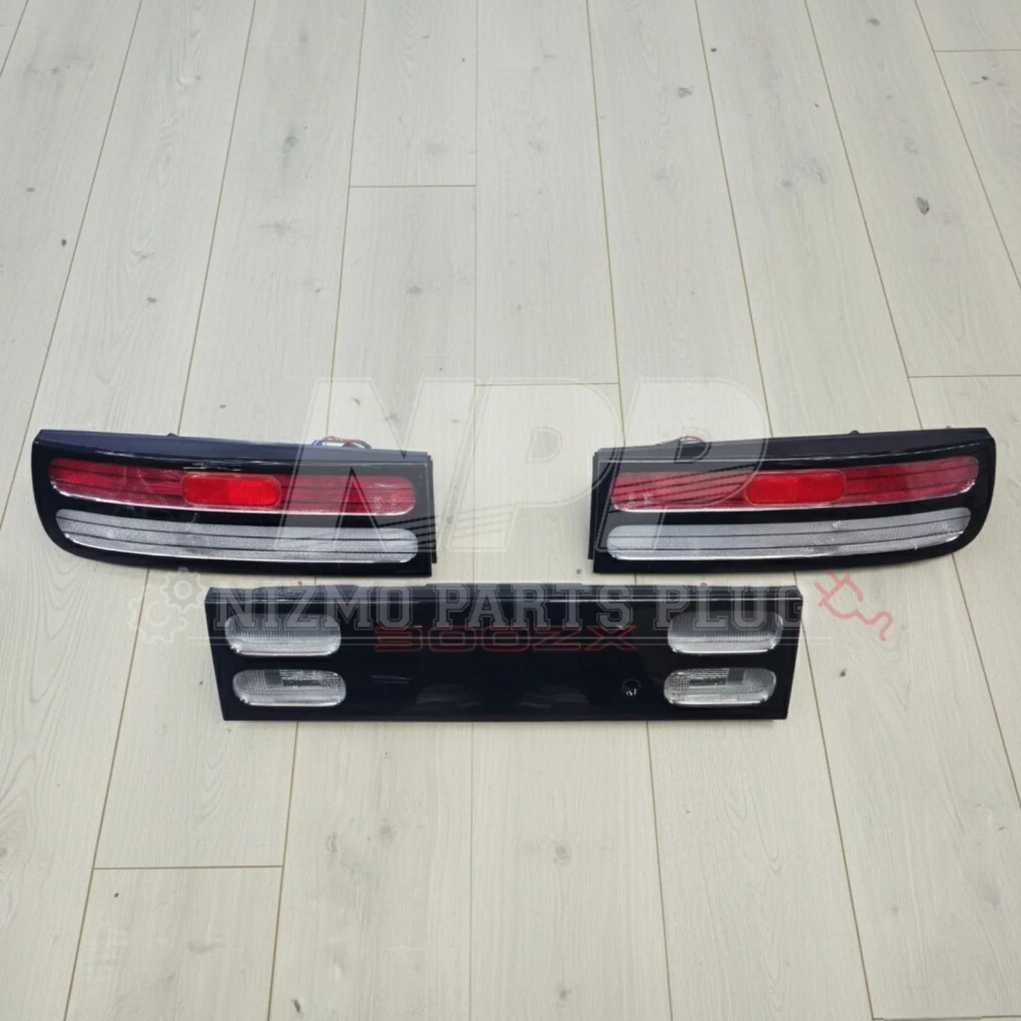 Nissan 300ZX tail lights and center panel set on light wood floor