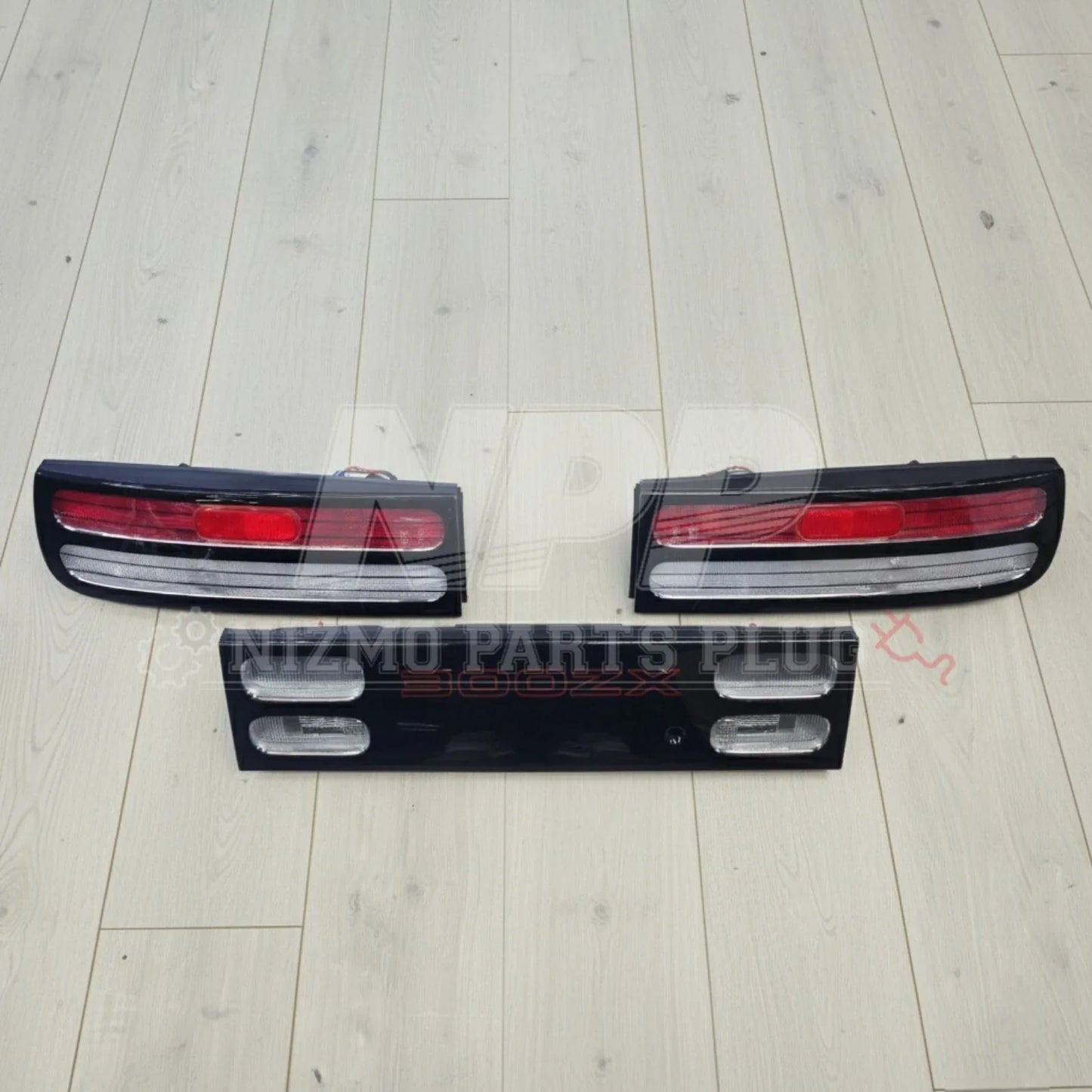 Nissan 300ZX tail lights and center panel set on light wood floor