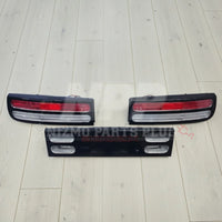 Nissan 300ZX tail lights and center panel set on light wood floor