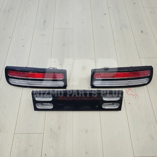 Nissan 300ZX tail lights and center panel set on light wood floor