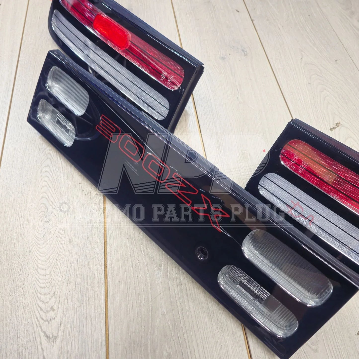Nissan 300ZX tail lights and center garnish set on light wood floor