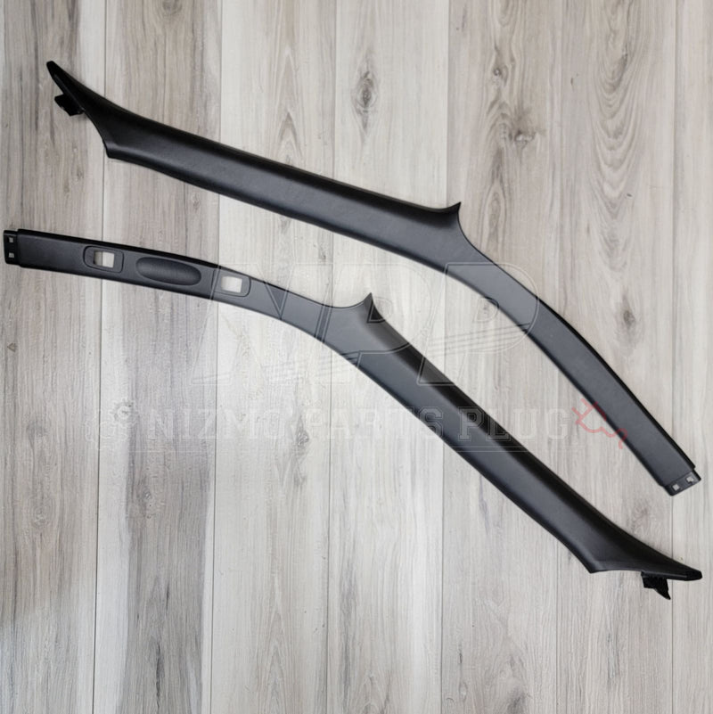 Load image into Gallery viewer, Black interior A-pillar garnish set for Nissan R34 Skyline Coupe. Good condition, clean finish on light wood floor.
