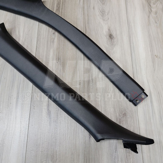 Black interior A-pillar garnish set for Nissan R34 Skyline, showing clean, textured plastic trim pieces.