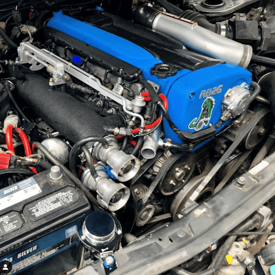 ZSPEC bolt kit installed on a Nissan Skyline R32/R33/R34 RB26 engine with blue valve covers and a custom sticker.