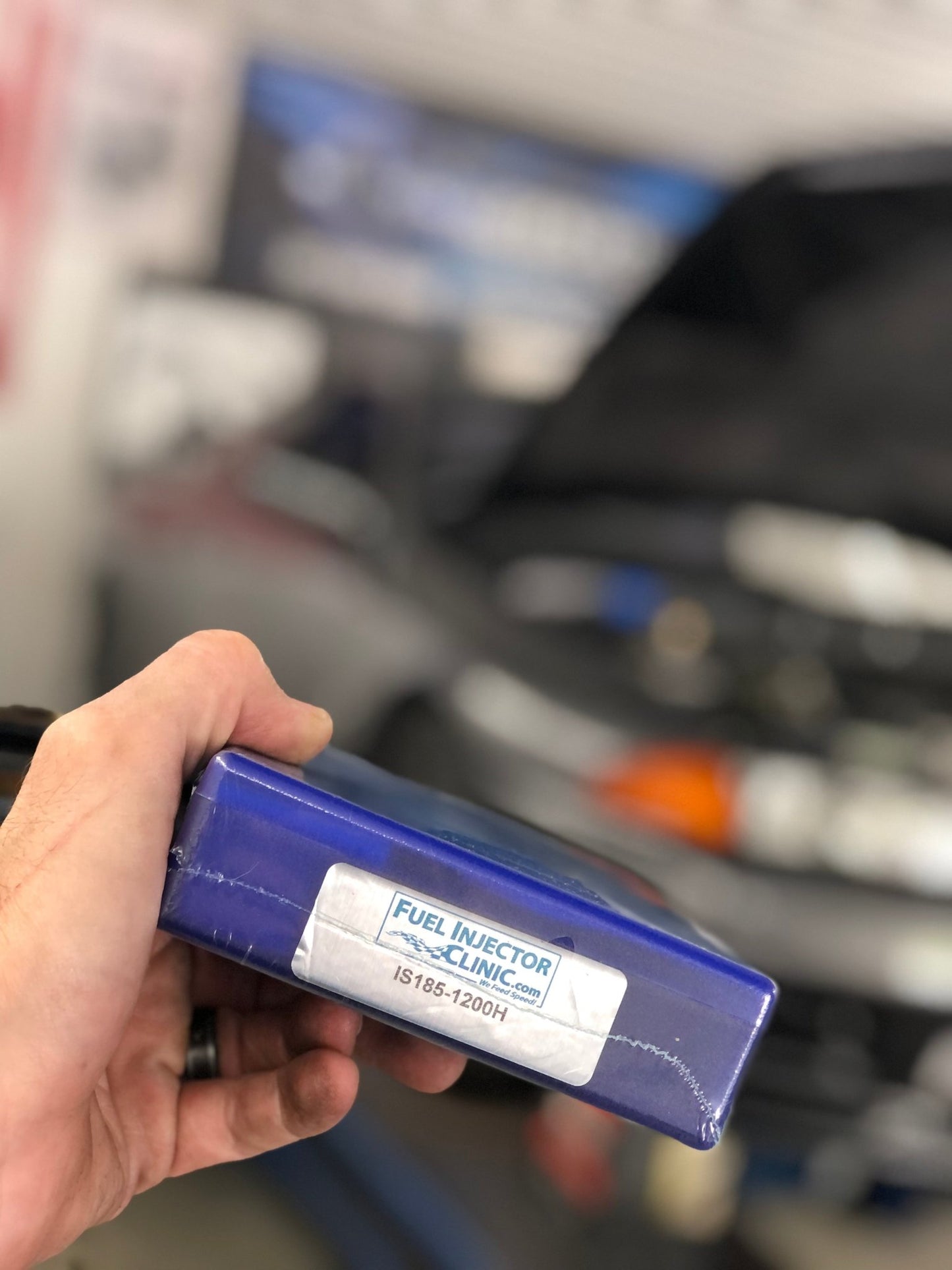 FIC 1200cc for 89-02 NIssan Skyline RB26 R32 R33 R34 Fuel Injector Set package shown in hand.