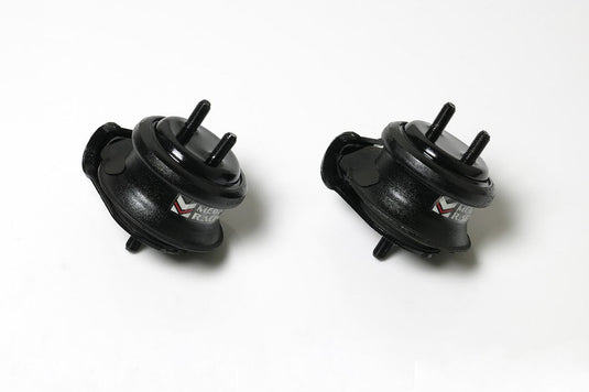 Two black Megan Racing hardened engine mounts for Nissan Skyline R33 and R34 with branded labels on white background.